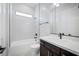Modern bathroom featuring a shower/tub combo, a toilet, and a vanity with light countertops and dark cabinetry at 10065 Auburn Rose Ave, Las Vegas, NV 89143