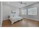 Bright bedroom with wood floors, a ceiling fan, and two large windows providing natural light at 10065 Auburn Rose Ave, Las Vegas, NV 89143