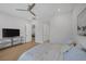 Clean bedroom with wood floors, light walls, ceiling fan, and a tv sitting on a console at 10065 Auburn Rose Ave, Las Vegas, NV 89143