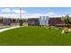 Community entrance with stone walls, modern design, lush green lawn, and beautiful landscaping at 10065 Auburn Rose Ave, Las Vegas, NV 89143