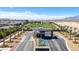 Welcoming community entrance with palm trees, lush landscaping, and attractive water feature at 10065 Auburn Rose Ave, Las Vegas, NV 89143