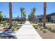 Palm-lined community walkway leads to luxurious homes, pool, and landscaped grounds at 10065 Auburn Rose Ave, Las Vegas, NV 89143