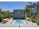 Inviting hot tub area with stone water feature, seating, and lush landscaping at 10065 Auburn Rose Ave, Las Vegas, NV 89143