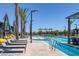 Relaxing community pool features lounge chairs, palm trees, and pristine blue water at 10065 Auburn Rose Ave, Las Vegas, NV 89143