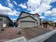 View of front exterior showing a two-story home, two-car garage, brick driveway, and desert landscaping at 10134 Reflection Brook Ave, Las Vegas, NV 89148