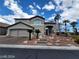 Charming two-story home featuring a stucco exterior, a two-car garage, and landscaped front yard with desert plants at 10134 Reflection Brook Ave, Las Vegas, NV 89148