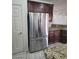 Kitchen featuring a stainless steel refrigerator next to pantry and dark wood cabinets at 10134 Reflection Brook Ave, Las Vegas, NV 89148