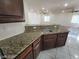 The kitchen sink is surrounded by granite counters and dark wood cabinets at 10134 Reflection Brook Ave, Las Vegas, NV 89148