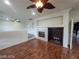 Living room with fireplace, dark wood floors and a ceiling fan at 10134 Reflection Brook Ave, Las Vegas, NV 89148
