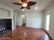 Bright living room with fireplace, dark wood floors, ceiling fan and open doorway at 10134 Reflection Brook Ave, Las Vegas, NV 89148