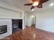 Living room with fireplace, dark wood floors, ceiling fan and open doorway at 10134 Reflection Brook Ave, Las Vegas, NV 89148