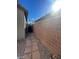 Narrow side yard featuring brick privacy wall, gate, and brick pavers at 10134 Reflection Brook Ave, Las Vegas, NV 89148