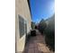 Side yard with brick paver walkway, shrubbery, and two AC units next to home at 10134 Reflection Brook Ave, Las Vegas, NV 89148