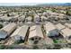 An elevated view of a desert neighborhood filled with single-Gathering homes with tile roofs at 10532 Beachwalk Pl, Las Vegas, NV 89144