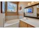 Well-lit bathroom featuring a soaking tub, a large window, and stylish wall decor at 10532 Beachwalk Pl, Las Vegas, NV 89144