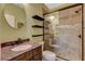 Tiled bathroom featuring glass enclosed shower, vanity with marble countertop and dark wood cabinets at 10532 Beachwalk Pl, Las Vegas, NV 89144