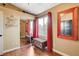 Bedroom with wood floor, colorful chest, red curtains and mirror, and a sliding closet door at 10532 Beachwalk Pl, Las Vegas, NV 89144