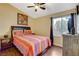 Comfortable bedroom with wood floor, a ceiling fan and a large window allowing ample light at 10532 Beachwalk Pl, Las Vegas, NV 89144