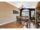 Elegant dining room with hardwood floors, stylish lighting, and a large window overlooking the backyard at 10532 Beachwalk Pl, Las Vegas, NV 89144