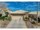 Exterior of a single-Gathering home boasting a two-car garage, desert landscaping, and tile roof at 10532 Beachwalk Pl, Las Vegas, NV 89144