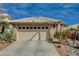 View of the front of a single-story home, highlighting its two-car garage and tiled roof at 10532 Beachwalk Pl, Las Vegas, NV 89144