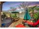 Charming backyard patio with outdoor seating, lush plants, and decorative sun accents at 10532 Beachwalk Pl, Las Vegas, NV 89144