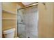 Modern shower with glass doors, tiled walls, and convenient built-in shelving at 10532 Beachwalk Pl, Las Vegas, NV 89144