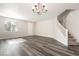 Bright living room showcasing hardwood floors, a chandelier, and a staircase leading to the upper level at 11273 Accademia Ct, Las Vegas, NV 89141