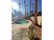 Private backyard oasis featuring a pool with a unique rock waterfall and tropical palm trees at 1213 Daytona Ln, Las Vegas, NV 89117