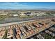Community aerial view showing many homes with solar panels, set against a commercial background and distant mountains at 1908 Morro Vista Dr, Las Vegas, NV 89135