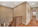 Upstairs hallway with wood railing, neutral walls, and a view into the living space below at 1908 Morro Vista Dr, Las Vegas, NV 89135