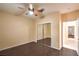 Neutral bedroom with a ceiling fan, wood floors, closet with mirror doors, and an open door to the hall at 1992 Fort Halifax St, Henderson, NV 89052