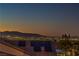 Panoramic dusk view of the city skyline and mountains from the rooftop with solar panels at 1992 Fort Halifax St, Henderson, NV 89052