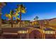 Elegant gated entrance with palm trees illuminated at dusk in a desert community at 1992 Fort Halifax St, Henderson, NV 89052