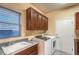 Well-lit laundry room with a sink, washer, dryer, cabinets, and ample counter space at 1992 Fort Halifax St, Henderson, NV 89052