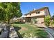 Inviting backyard showcasing a lush lawn, a covered patio, mature trees, and comfortable bench seating at 2233 Marlboro Dr, Henderson, NV 89014