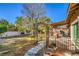 Large backyard featuring a covered patio, mature trees, lawn, and walkways at 2233 Marlboro Dr, Henderson, NV 89014