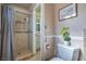 Bathroom featuring a tiled standing shower with glass door and a toilet with green plants at 2233 Marlboro Dr, Henderson, NV 89014
