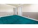 Cozy bedroom with plush turquoise carpet, wainscoting, and ample closet space for organized storage at 2233 Marlboro Dr, Henderson, NV 89014