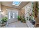 Bright foyer with tiled floors, a skylight, and lots of natural light, adorned with lush greenery at 2233 Marlboro Dr, Henderson, NV 89014