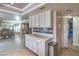 Open kitchen showcasing white cabinets, countertops, stainless steel appliances, and seamless transition to dining area at 2233 Marlboro Dr, Henderson, NV 89014