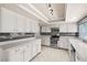 Well-lit kitchen with white cabinets, stainless steel appliances, and ample countertop space at 2233 Marlboro Dr, Henderson, NV 89014