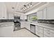 Updated kitchen features white cabinets, stainless steel appliances, and modern backsplash at 2233 Marlboro Dr, Henderson, NV 89014