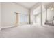 Spacious living room with neutral carpet, large windows, and an open floor plan to the entryway and stairs at 2233 Marlboro Dr, Henderson, NV 89014