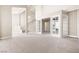 Large living space features neutral carpet and a view of the stairway and adjacent sunroom with glass doors at 2233 Marlboro Dr, Henderson, NV 89014