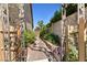 Charming side yard with a stone pathway, lush greenery, and a decorative iron gate for privacy at 2233 Marlboro Dr, Henderson, NV 89014