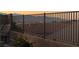 A wrought iron backyard fence with a view of the city lights and mountains in the distance at 2568 Dirleton Pl, Henderson, NV 89044