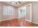 Bedroom with hardwood floors, a ceiling fan, shuttered windows, and a partially opened glass door at 2568 Dirleton Pl, Henderson, NV 89044