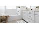 Bright bathroom featuring a bathtub, white cabinets, and a window that provides natural light at 2665 Piroli St, Henderson, NV 89044