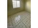 Neutrally painted bedroom featuring window and tile flooring at 2705 Howard Dr, Las Vegas, NV 89104